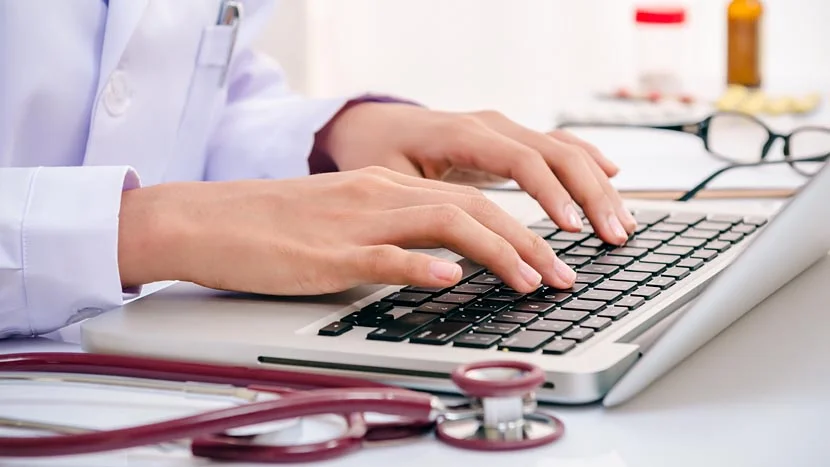 Una persona escribiendo en una computadora portátil