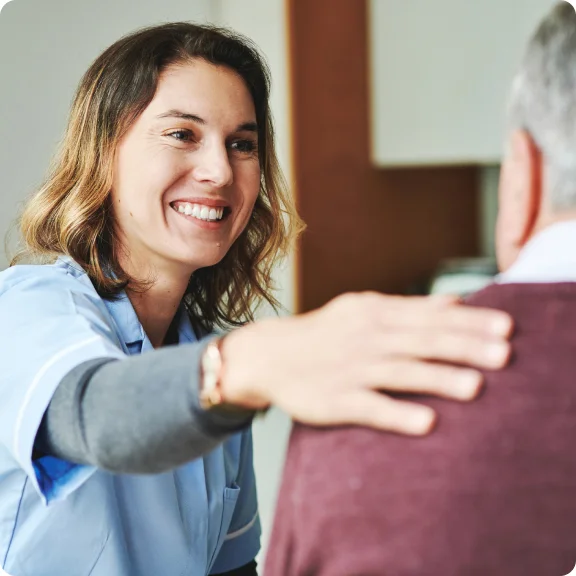 A nurse is greeting an elderly man.