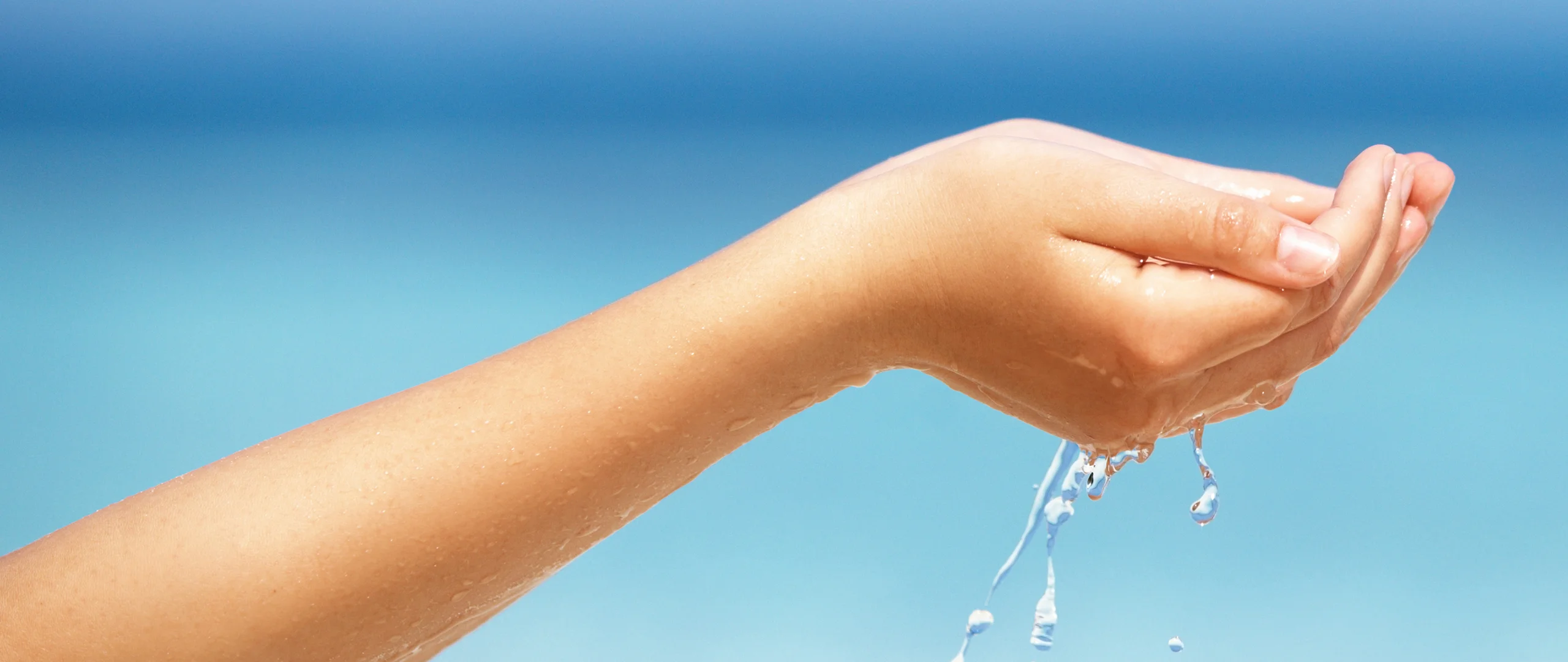 ręka trzymająca sznurek wody