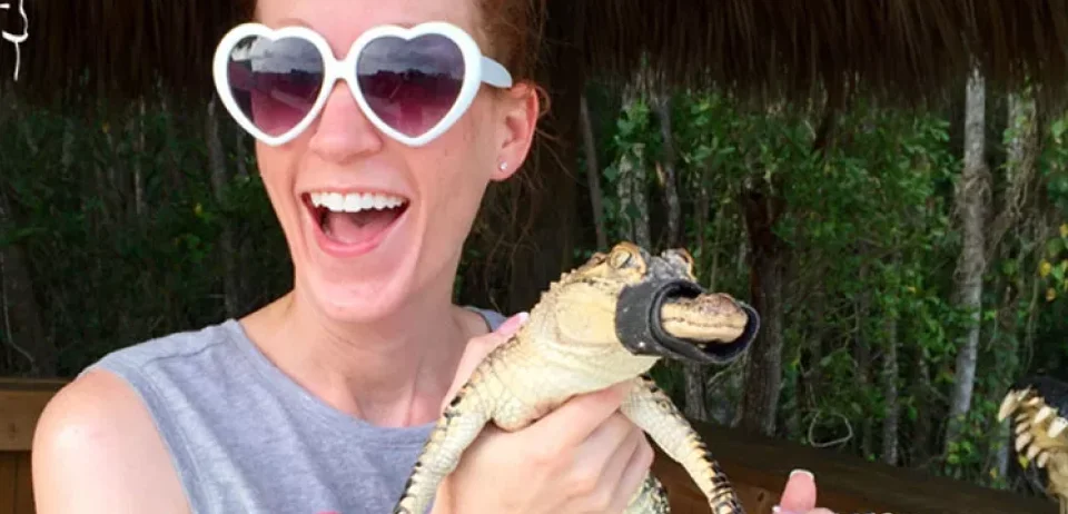 a woman holding a lizard